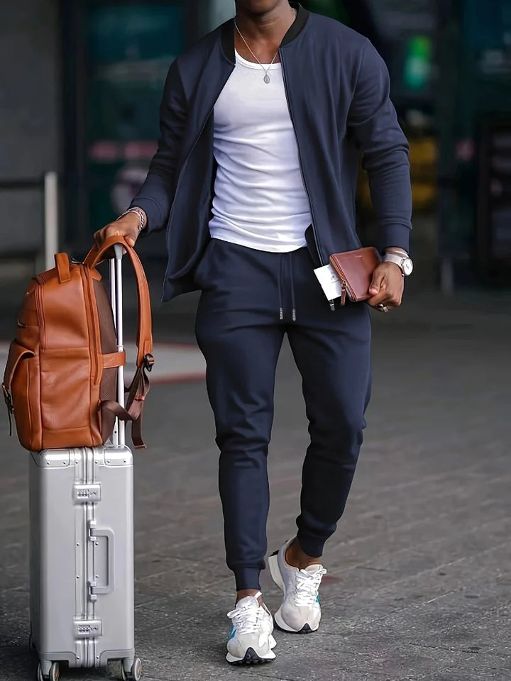 Men's athletic two-piece tracksuit set with a full zip-up jacket & comfy jogger pants for casual or lounge wear.