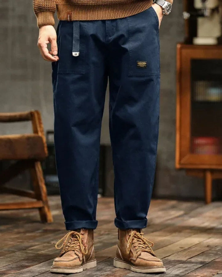 Close-up of men's vintage cargo pants showing durable fabric & detailed utility pockets, ideal for modern streetwear.
