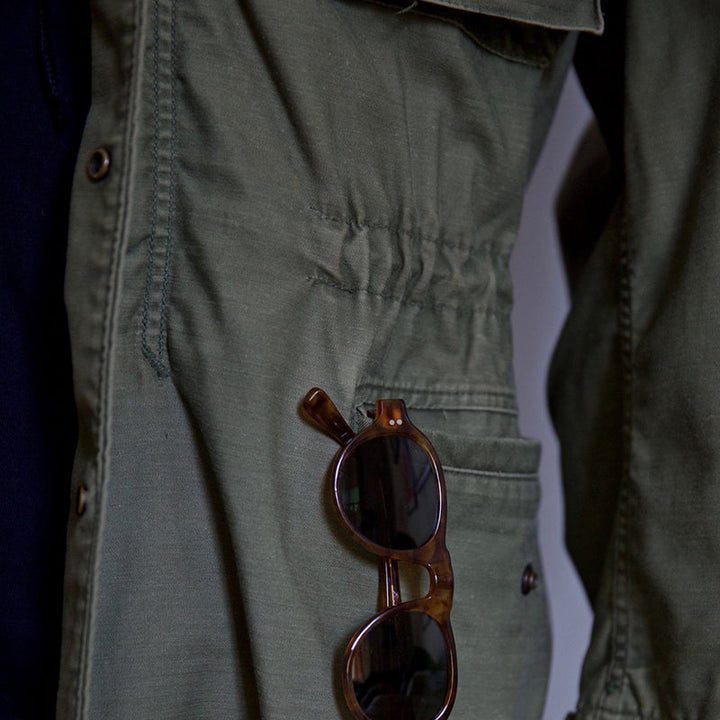 Stylish men's vintage military jacket for adventure gear. Features a hidden hood and rugged cargo pockets.