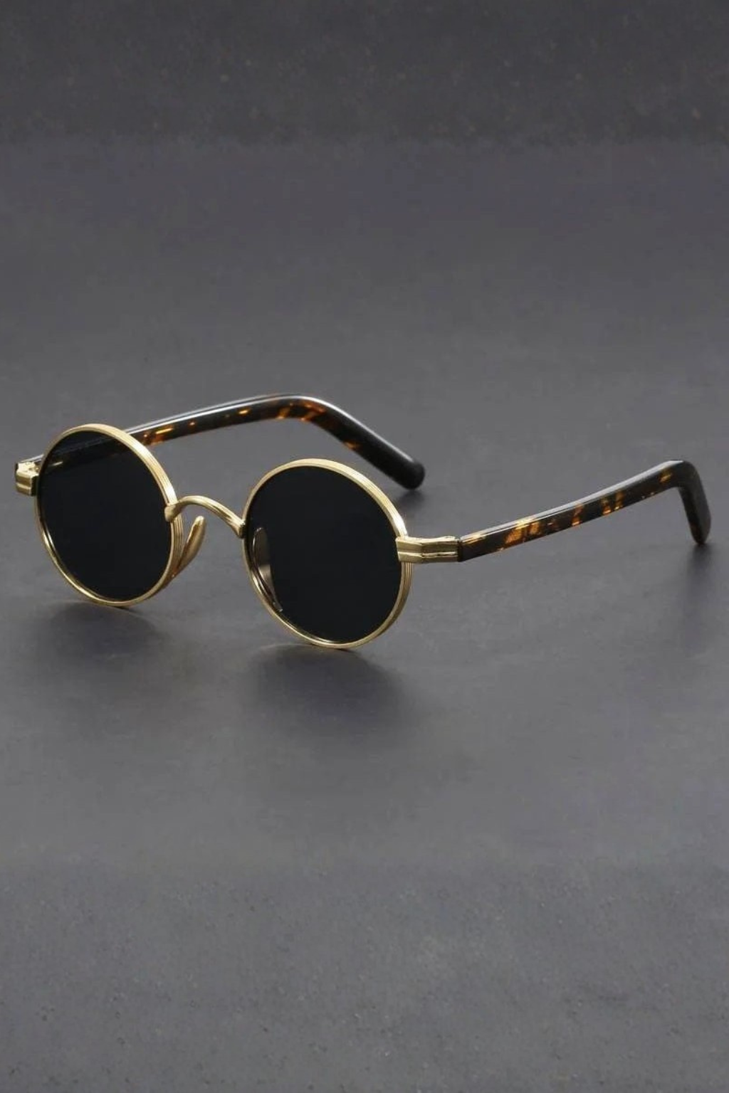 Close-up of men's vintage round sunglasses. Metallic frame, UV400 protection. A classic retro fashion eyewear accessory.