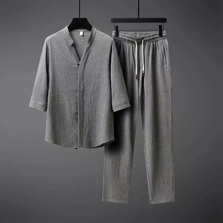 Men's vintage style black two-piece tracksuit set with button-down top & elastic waist pants for casual spring wear.