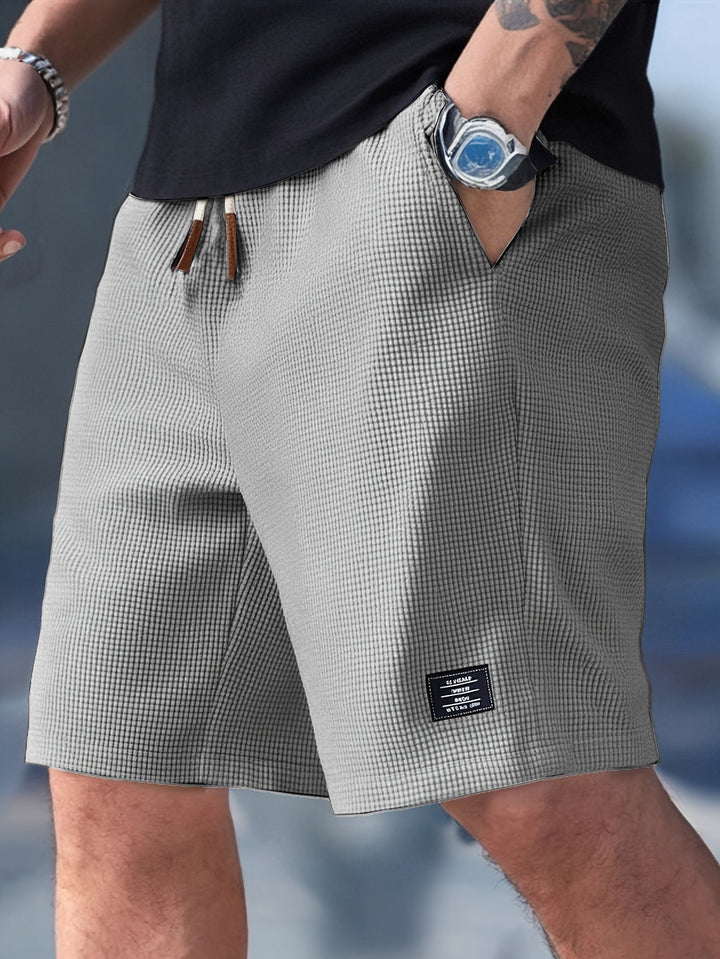 Lightweight men's waffle shorts with adjustable drawstring. Essential for casual summer outfits.