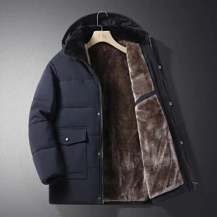 Man wearing a black insulated outdoor jacket with hood, designed for winter protection & casual cold weather wear.
