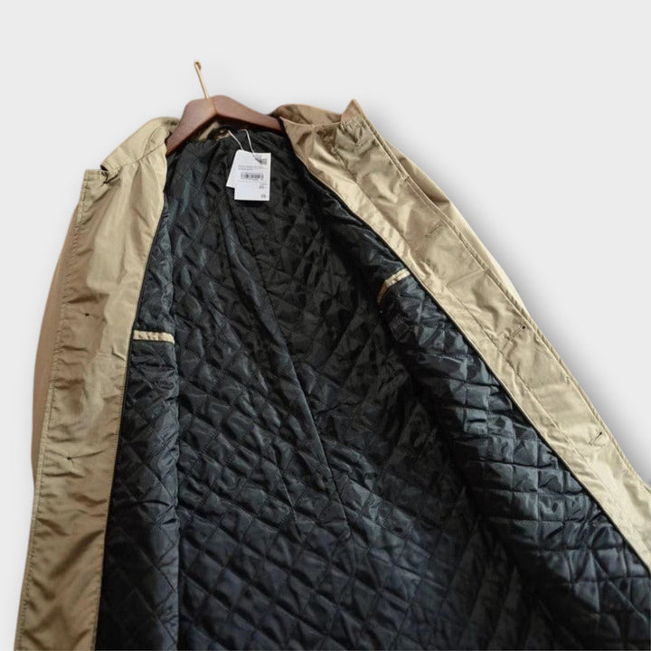 Close-up of the fabric texture on a men's weatherproof insulated long coat, ideal for cold weather.
