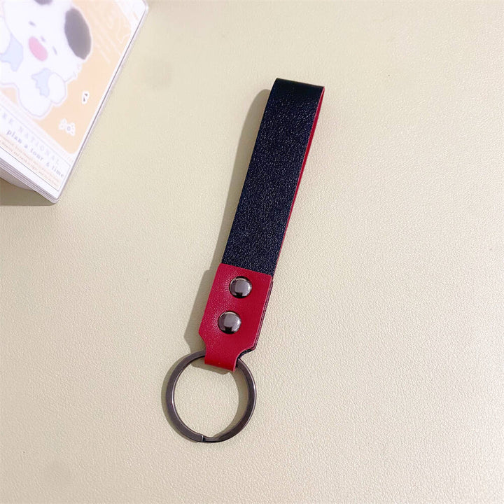 Hand holding a sleek minimalist leather keychain, showing its compact everyday carry design.