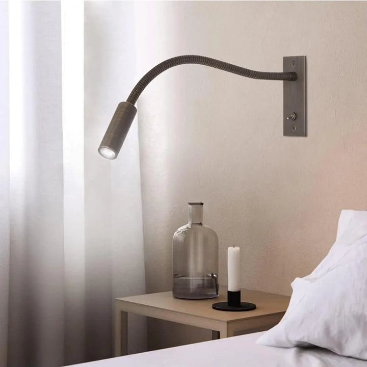 Modern metal LED wall lamp, sleek minimalist design, ideal adjustable spotlight for bedside reading.