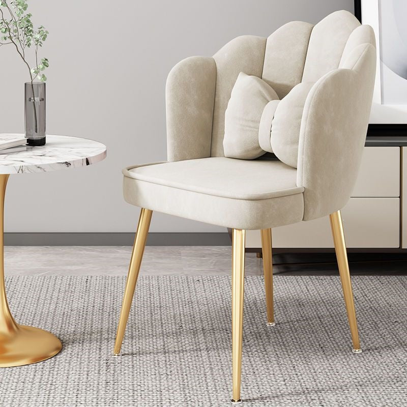 Green accent chair with polished gold legs, adding a pop of color to decor.