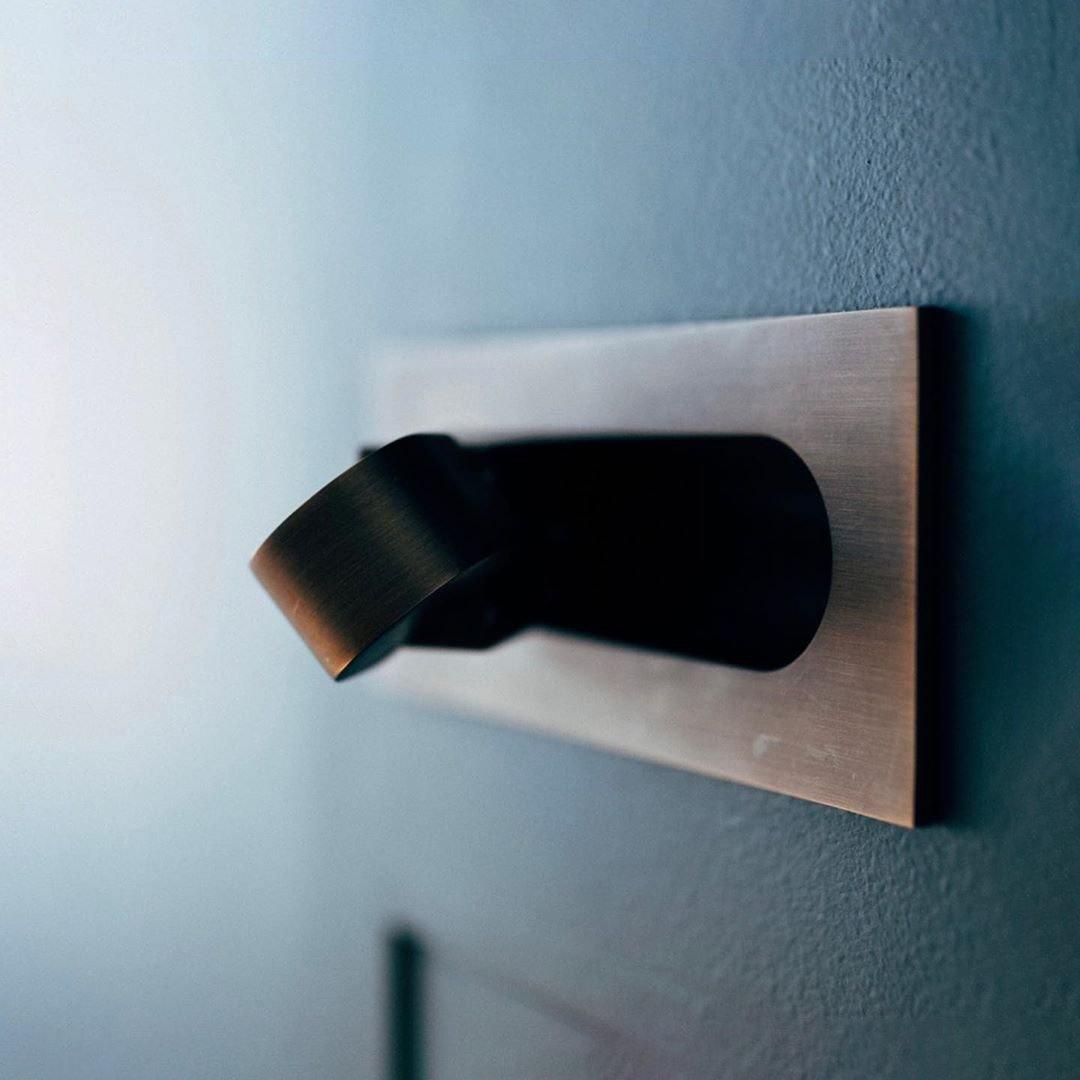 Bedside LED wall lamp with an adjustable head, providing focused illumination for reading.
