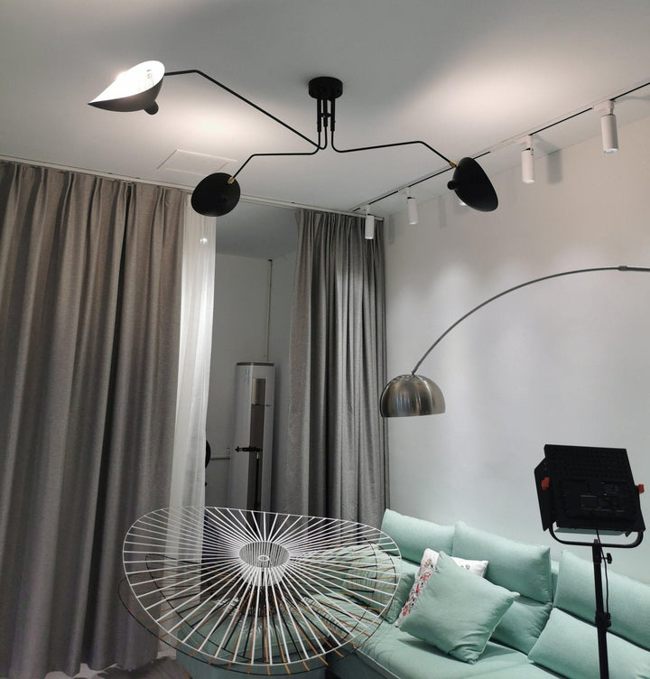 Minimalist adjustable multi-arm ceiling lamp, sleek metal design for bedroom lighting.