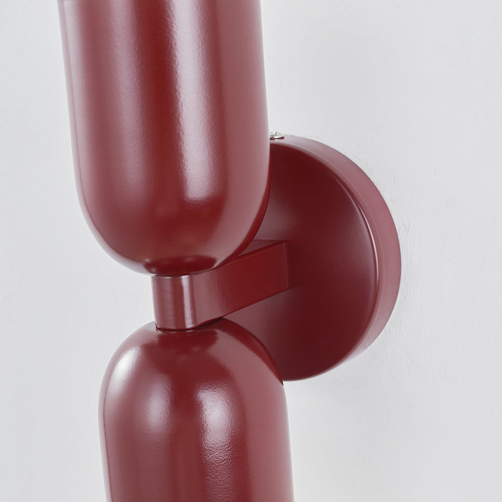 Vertical cylinder LED wall lamp, contemporary design, for stairwells or entryways.