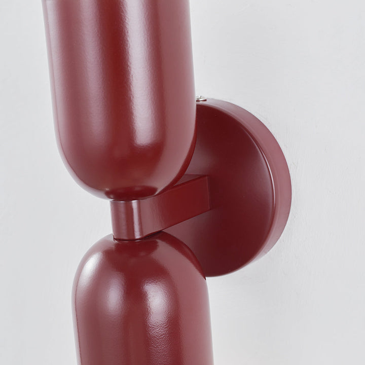 Vertical cylinder LED wall lamp, contemporary design, for stairwells or entryways.