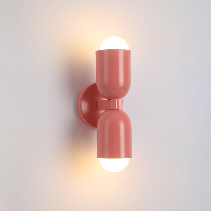 Minimalist grey metal cylinder wall sconce, integrated LED, provides ambient lighting.
