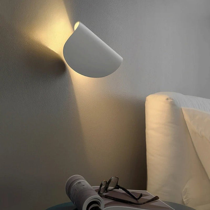 Black modern LED up down wall lamp, creating dramatic shadows and light effects on walls.
