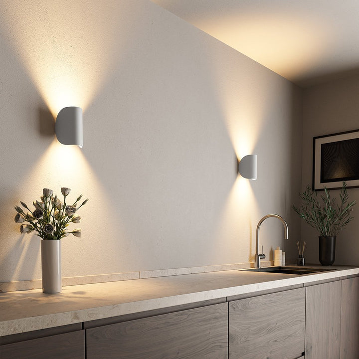 White contemporary LED wall sconce, providing soft up down ambient lighting for bedrooms.