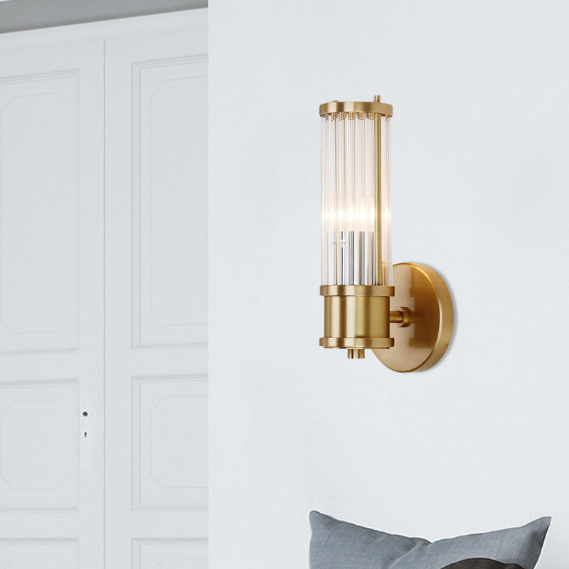 Durable gold wall sconce with clear crystal cylinder, a chic and modern indoor lighting solution.