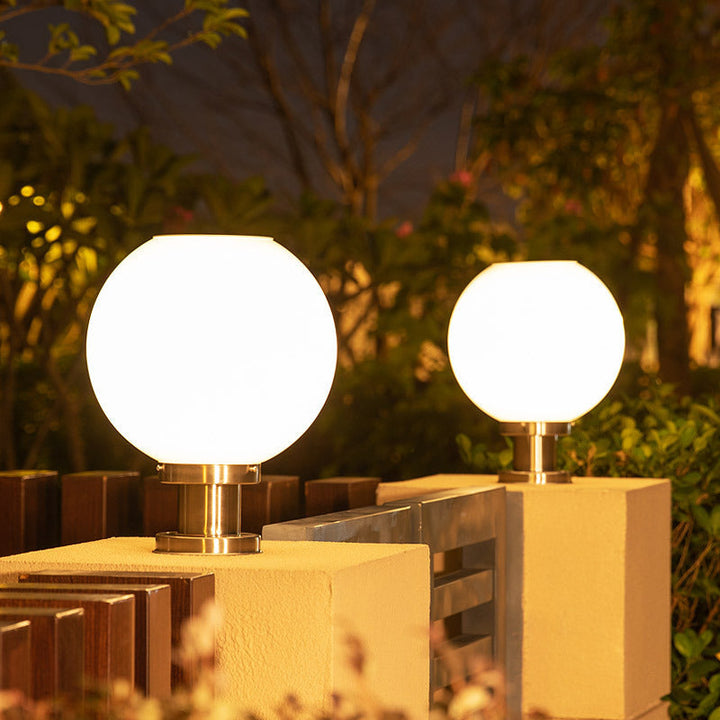 Modern globe outdoor fence post light, weather-resistant for garden & pathway lighting. Enhances exterior decor.
