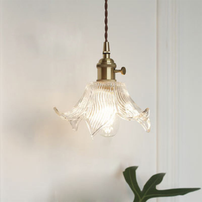 Modern industrial clear glass single pendant light, minimalist design for kitchen or dining.