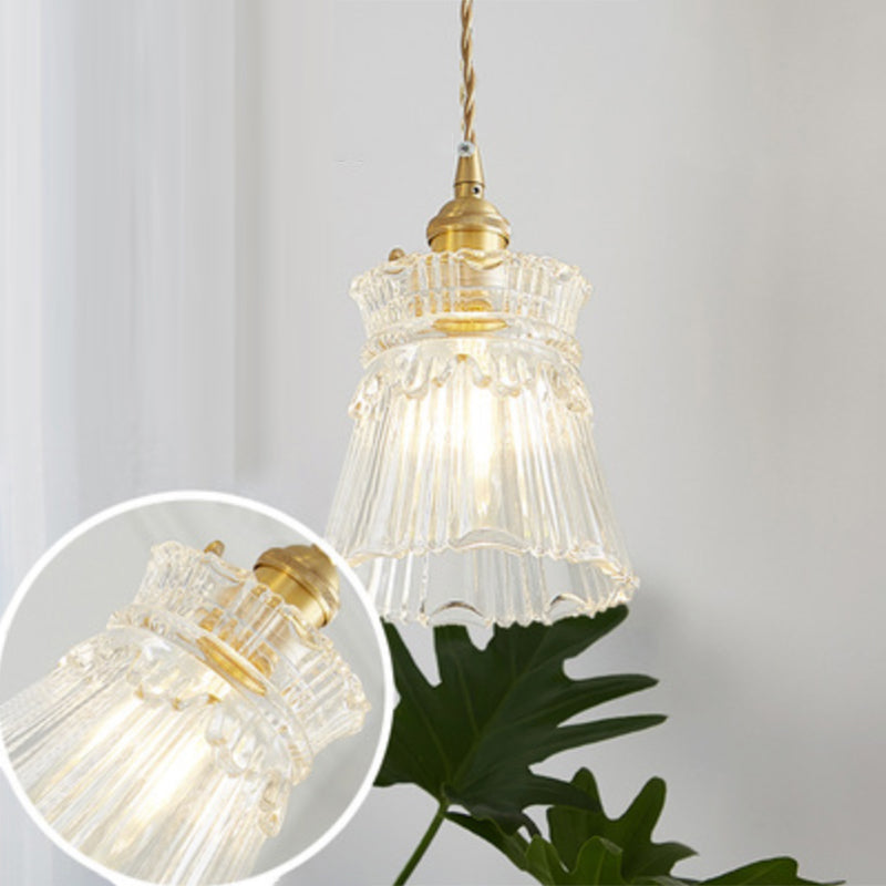 Modern industrial clear glass pendant light creating a warm, inviting glow.