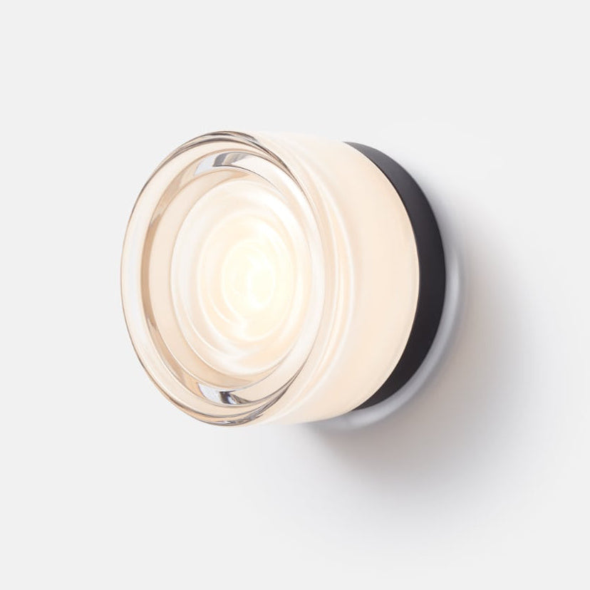 Minimalist modern LED wall sconce with customizable base & glass, enhancing interior decor.