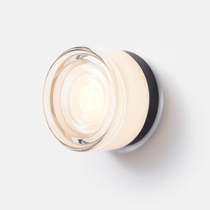 Minimalist modern LED wall sconce with customizable base & glass, enhancing interior decor.