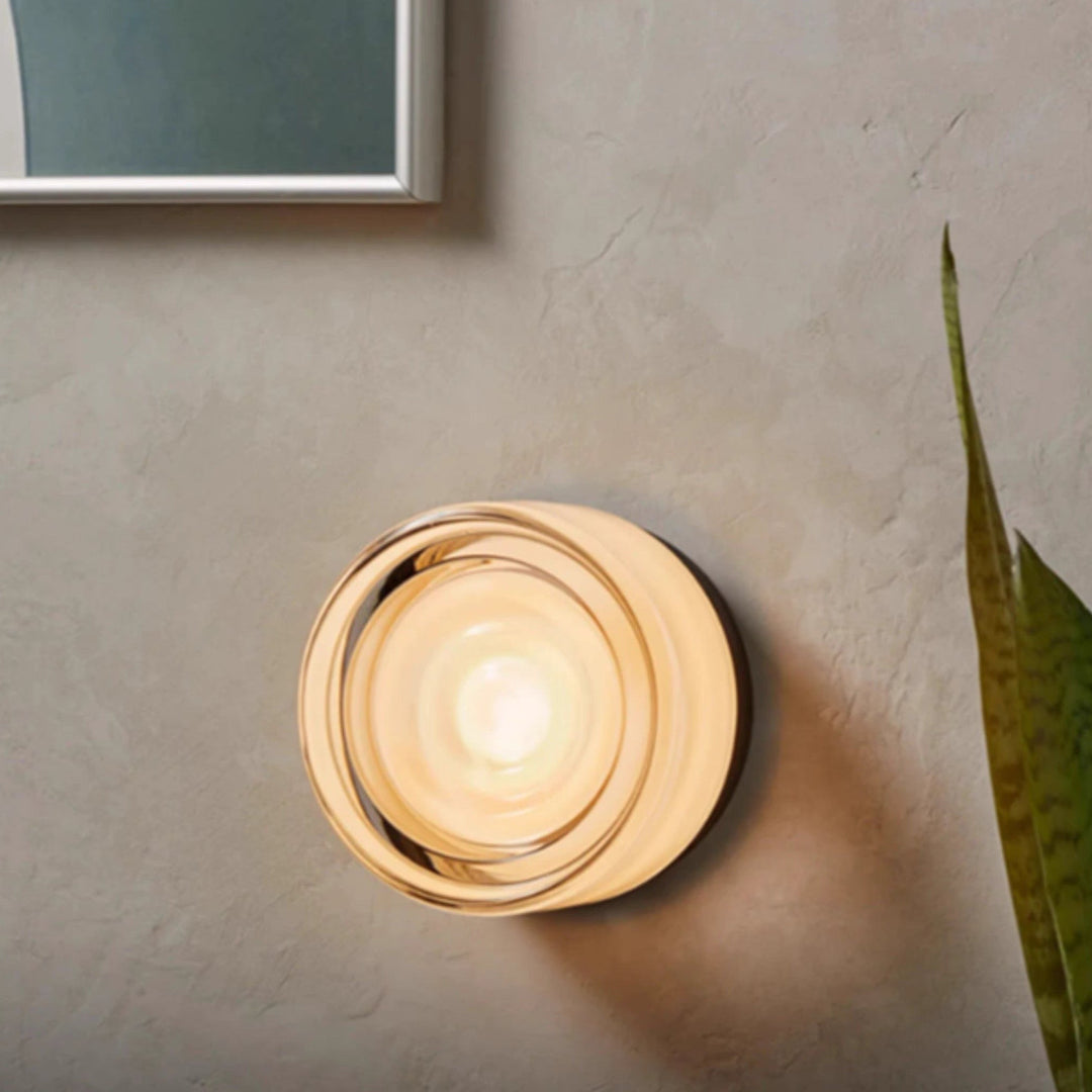 Modern LED wall sconce featuring elegant glass & minimalist base for indoor ambient light.
