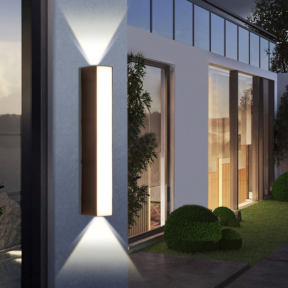 Up/down outdoor LED wall light, casting dramatic light patterns on a modern home exterior.