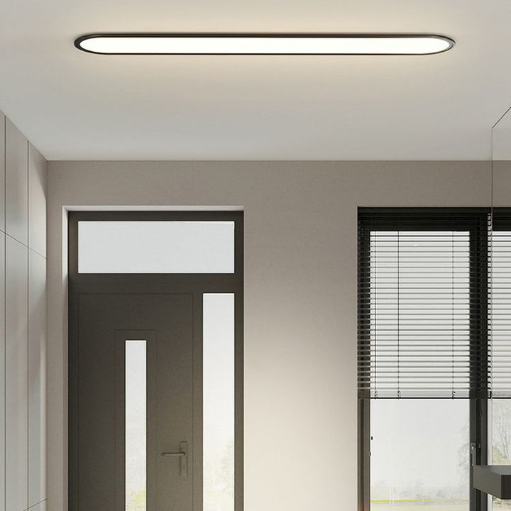 White light oval LED flush mount, sleek modern fixture for home interior.