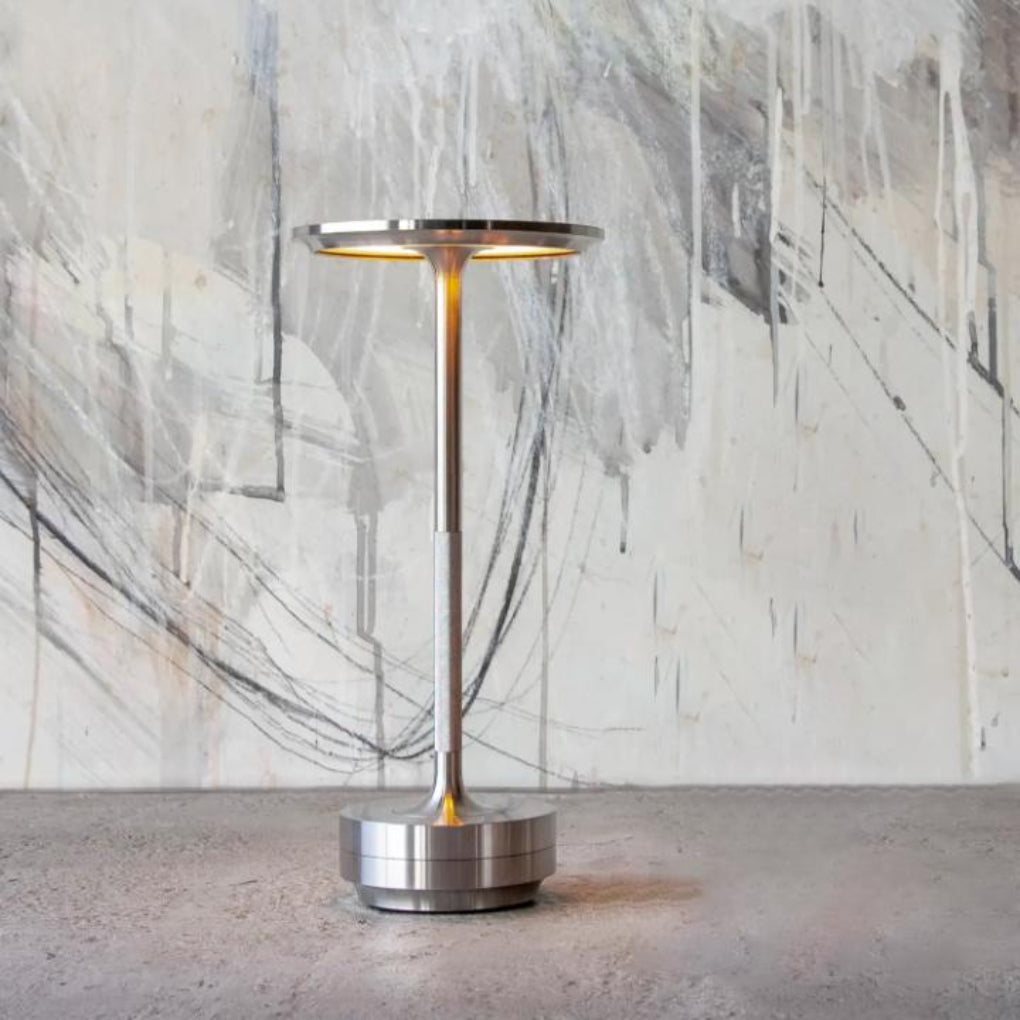 Cordless rechargeable lamp illuminating a stylish living room, providing warm, dimmable ambient lighting.