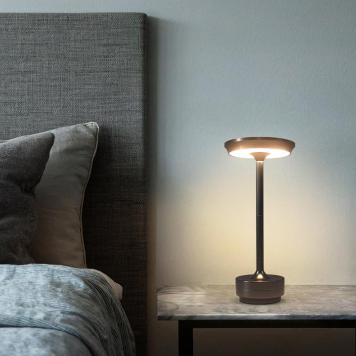 Outdoor portable table lamp enhancing a patio setting, a modern cordless light for evening gatherings.