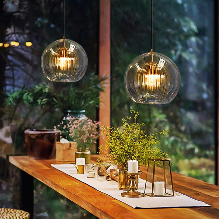 Clear glass globe pendant light, a modern ceiling lamp for stylish bedroom or dining areas.