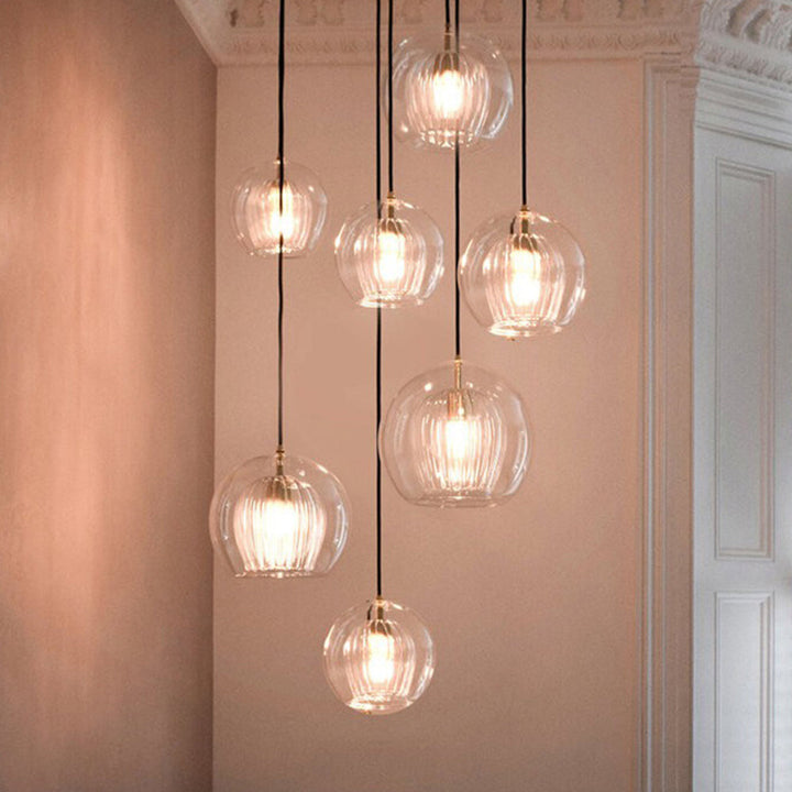 Elegant spherical pendant light, adjustable glass fixture for modern home lighting design.