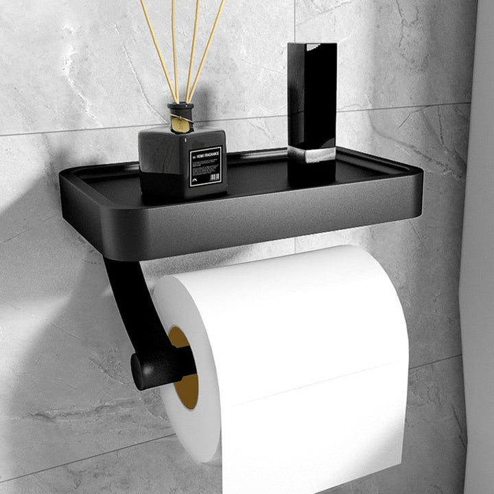 Modern stainless steel toilet roll holder with integrated storage shelf for bathroom organization.