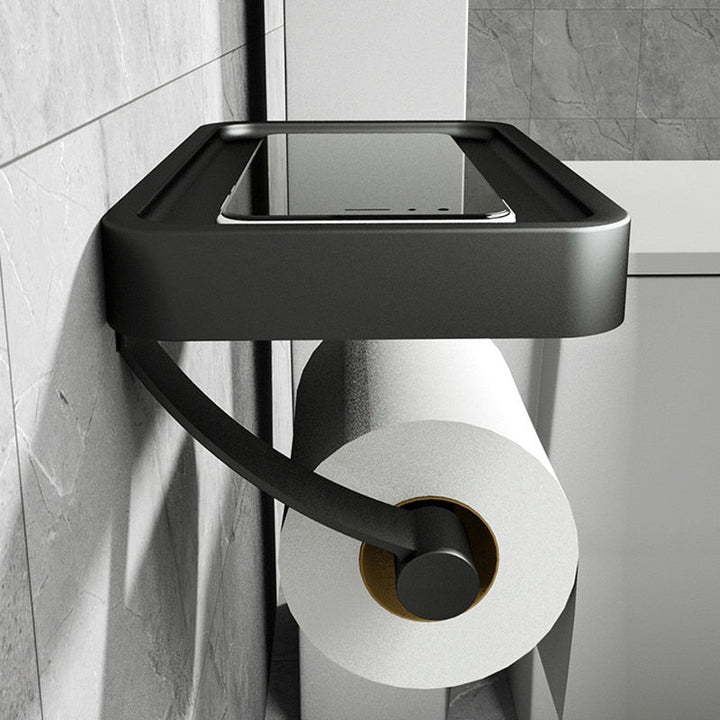 Durable stainless steel toilet roll holder featuring a convenient storage shelf, perfect for modern bathrooms.