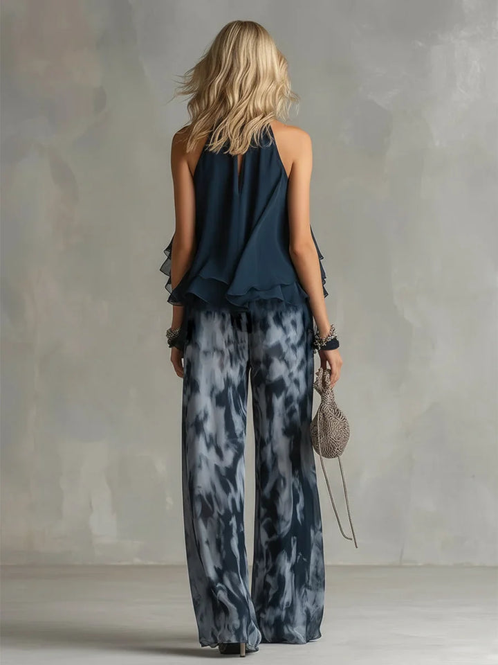 Woman wearing a navy tie-dye halter top and wide leg pants set, showcasing effortless summer fashion.