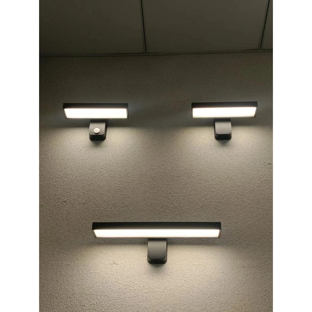 Wall-mounted waterproof LED motion sensor light, adjustable for outdoor areas.