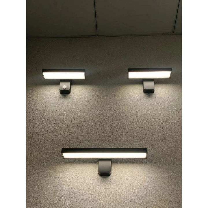 Wall-mounted waterproof LED motion sensor light, adjustable for outdoor areas.