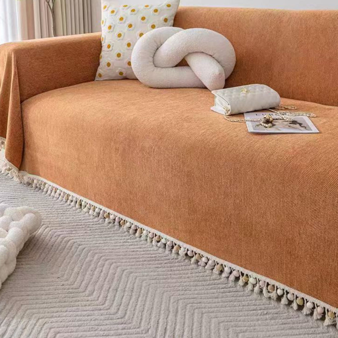 Modern pet-friendly herringbone couch protector with tassels, adding boho style to your living room.