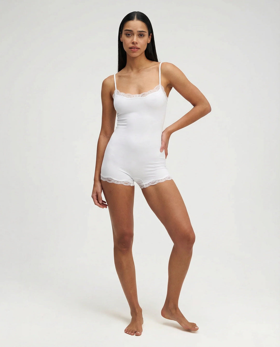 White feminine nightwear romper. Delicate lace trim cami playsuit for ultimate comfort loungewear.