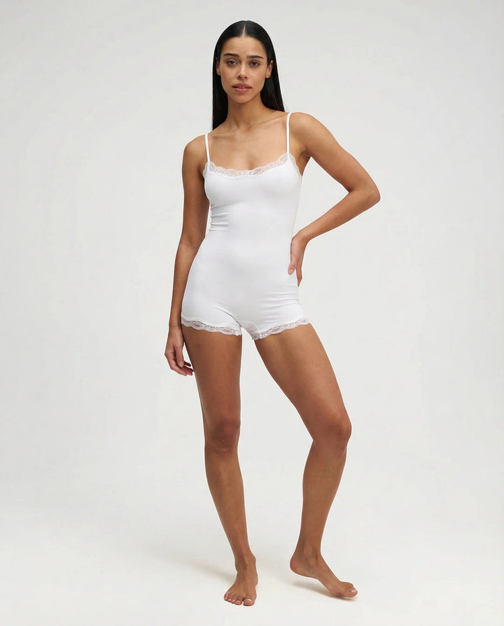 White feminine nightwear romper. Delicate lace trim cami playsuit for ultimate comfort loungewear.