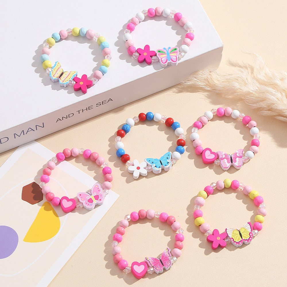 Playful women's/girls' charm bracelet featuring cute heart and butterfly charms on pink wooden beads.