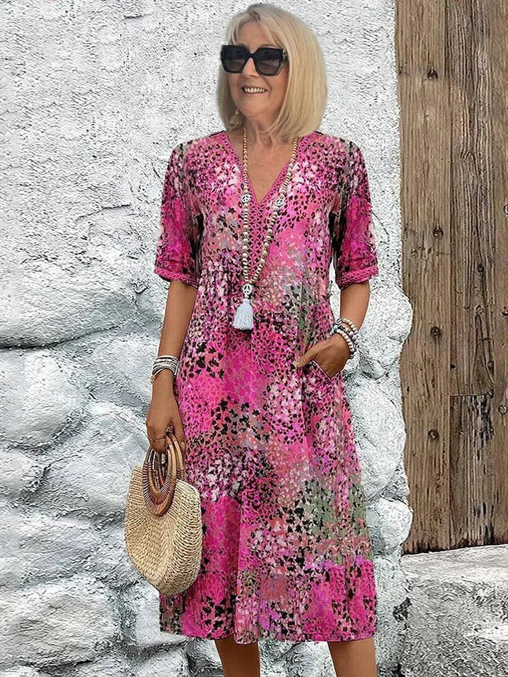 Comfortable women's plus size midi dress with vibrant floral print, V-neck, and practical side pockets.