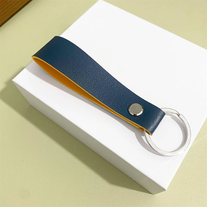 Compact black leather key fob holder, secure and stylish accessory.