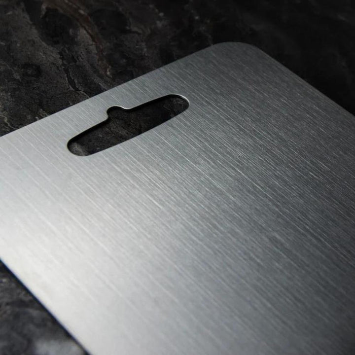Close-up of silver stainless steel cutting board, hygienic & non-slip for safe kitchen food prep.