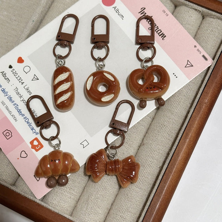 Cute bread-shaped keychain, a unique food-themed accessory for your keys or bag.