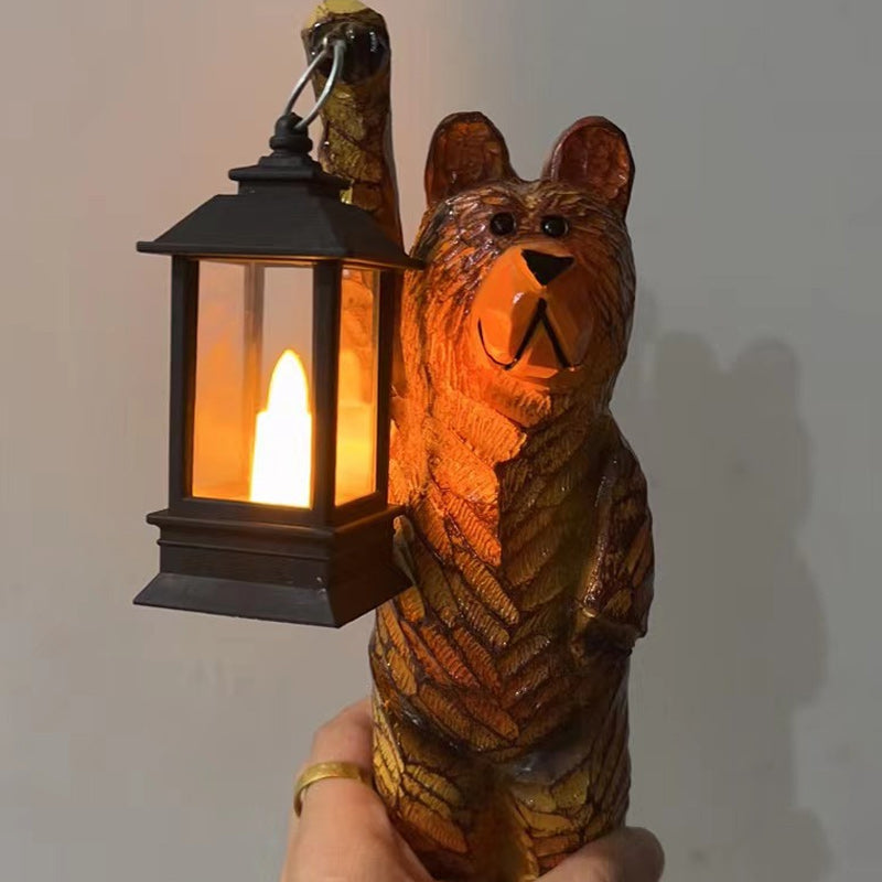 Outdoor carved bear solar lantern with a warm flickering LED light, adding rustic charm to any garden space.