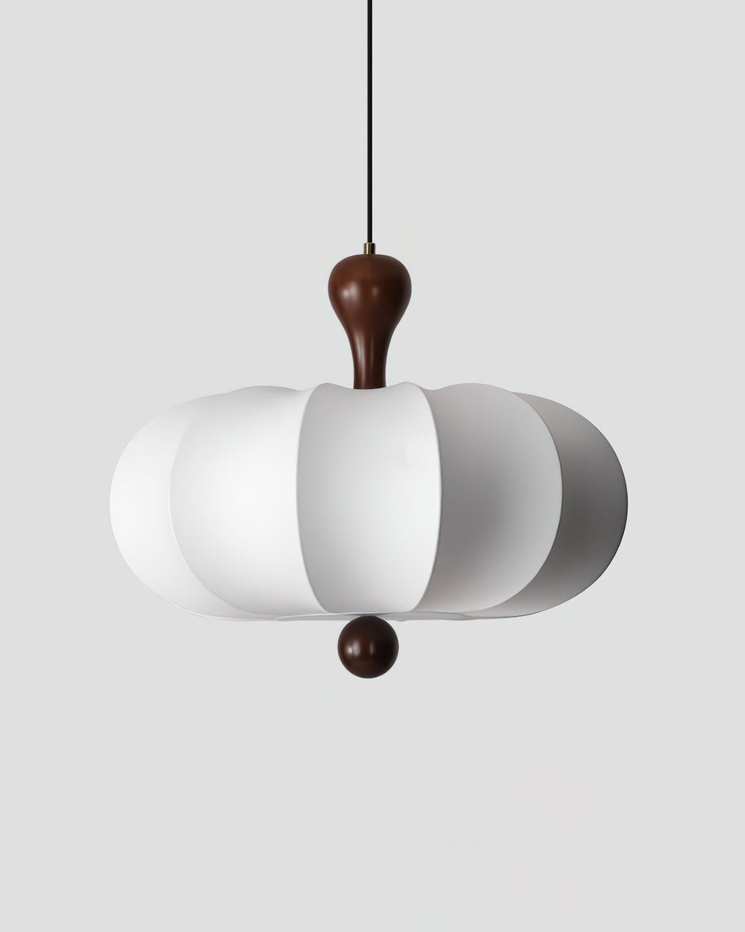 Sculptural walnut & white fabric pendant light illuminating a modern living room space.