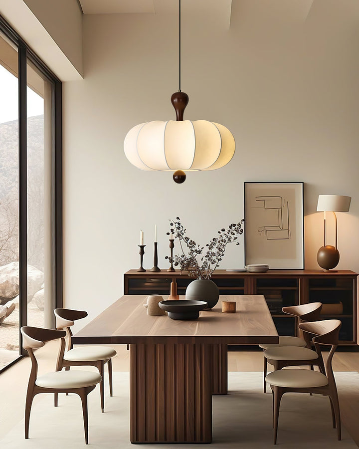 Textured white fabric shade of a sculptural walnut pendant light. Modern ceiling decor.