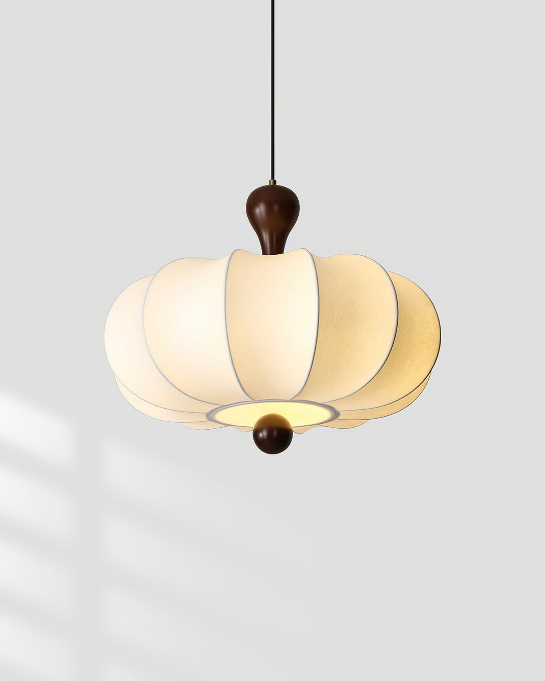Side view: Sculptural walnut & white fabric pendant light. Elegant modern home lighting design.