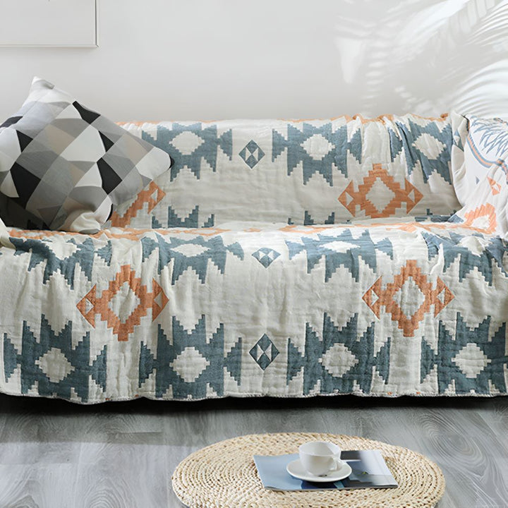 Soft cotton reversible muslin gauze blanket with geometric pattern, ideal for cozy home decor on sofa or bed.