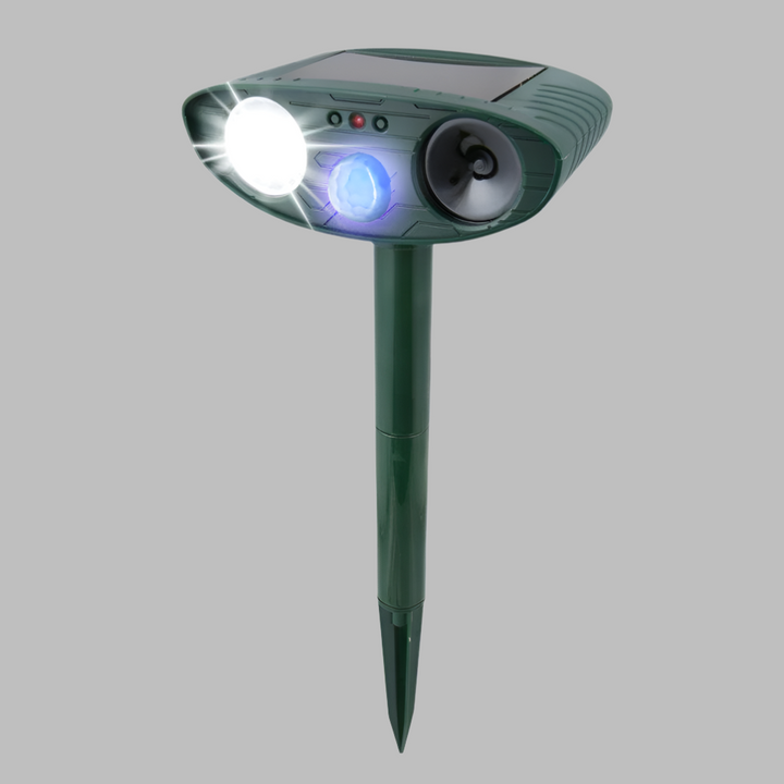 Solar ultrasonic rabbit repeller discreetly placed in garden for humane and effective pest control.